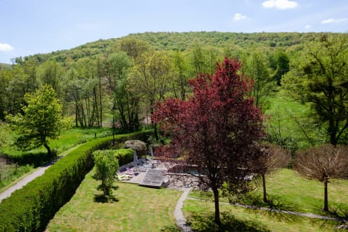 Moulin Renaudiots tuin met rode boom, hagen, beek en terras met uitzicht op het Autun-platteland