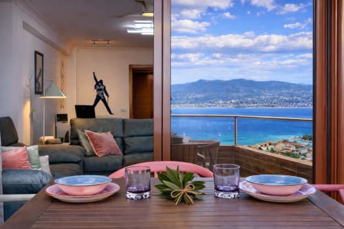 Elegante comedor del apartamento A Son do Mar en Baiona con vistas al mar, terraza y montañas costeras visibles