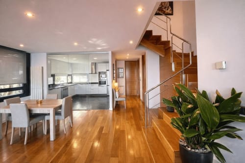 Moderno apartamento dúplex en Holibai con suelos de madera, cocina, comedor y escalera de madera en Baiona