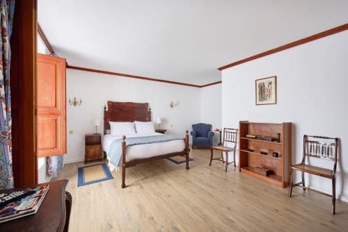 Spacious bedroom at Quinta da Alcaidaria-Mór with wooden furniture, period decor, and light wood flooring in Ourém-Fátima,