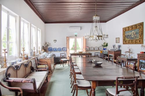 Elegant dining room at Quinta da Alcaidaria-Mór in Fátima with wooden ceiling, crystal chandelier, and period furniture