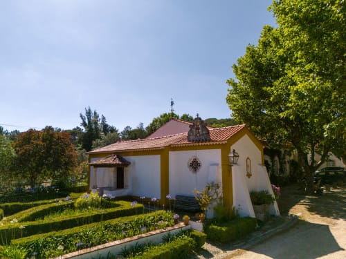 Charming white and yellow chapel at Quinta da Alcaidaria-Mór, a boutique retreat in Ourém near Fátima, Portugal