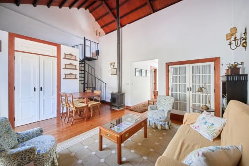 Spacious living room at Quinta da Alcaidaria-Mór with wooden beams, terra cotta accents, and coastal furniture in