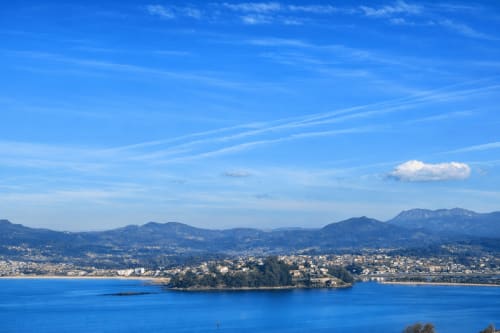 Vista costera de Baiona con bahía azul, montañas y pueblo marinero - apartamento con vistas al mar Holibai Beiramar