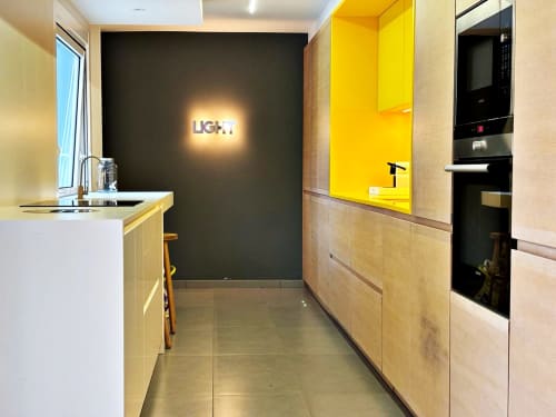 Cocina moderna en villa Vila Panxón, con armarios amarillos, pared de acento negro, electrodomésticos de acero inoxidable y luminosa
