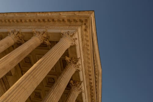 Classical columns with ornate capitals at Le Prieuré Notre-Dame, a charming bed and breakfast in Montfrin, France