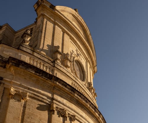 Golden stone architectural details of Le Prieuré Notre-Dame, a bed and breakfast in Montfrin, France, with ornate moldings
