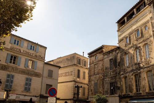 Historic stone buildings of Le Prieuré Notre-Dame in Montfrin, France with warm sunlight on traditional architecture