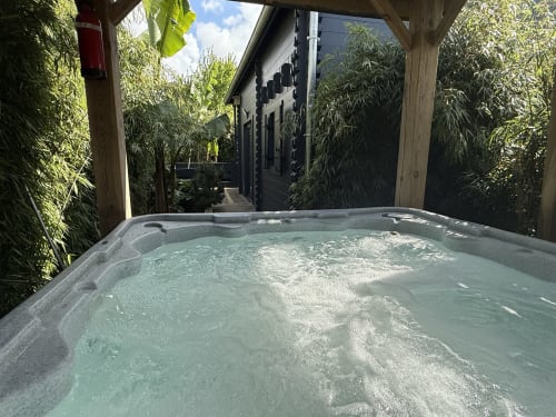 Jacuzzi privatif du cottage, avec vue sur bambon et bananier à Treguidel