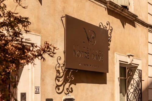 Le Prieuré Notre-Dame signage on terracotta-colored building facade in Montfrin, France