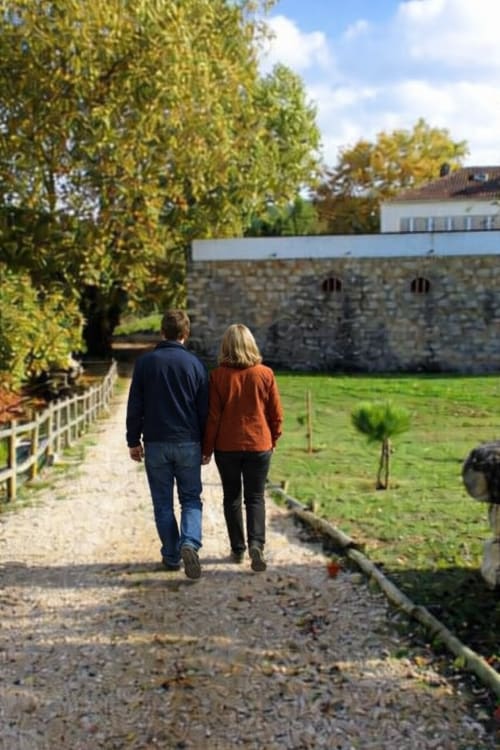 Casal caminhando na trilha da Quinta da Alcaidaria-Mór, retiro rural próximo a Fátima com muros de pedra