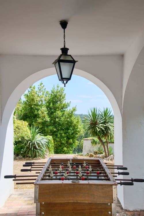 Mesa de sueca sob arcada branca na quinta Alcaidaria-Mór em Ourém-Fátima, Portugal