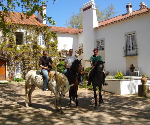 Guests horseback riding in courtyard of Quinta da Alcaidaria-Mór, a Portuguese quinta near Fátima