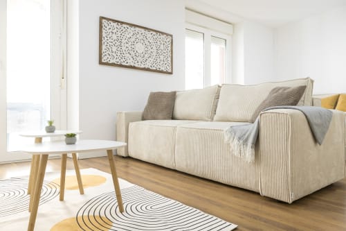Salón moderno del apartamento Ab Be Special Home en Málaga, con sofá beige, mesa de madera y vistas a la ciudad
