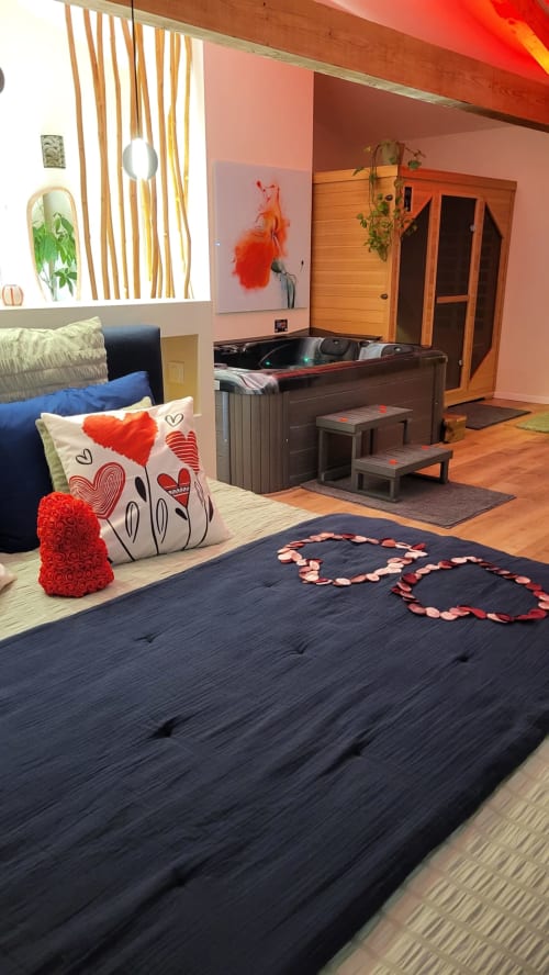 Suite romantique avec pétales de roses en forme de cœur sur le lit, bain à remous et murs roses au Suite & Duplex à Cabannes, France