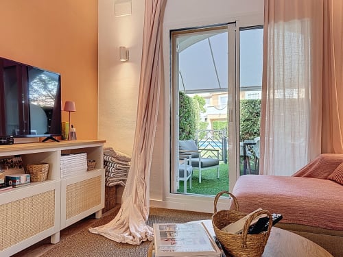 Dormitorio luminoso en la casa rural La Bella Lola en L'Estartit con vistas a la piscina, paredes naranja cálidas, TV moderna y puertas de cristal