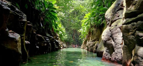 Canyon aux eaux turquoise et parois rocheuses majestueuses entourées de végétation luxuriante à Trois-Rivières, Guadeloupe