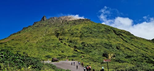 Montagne volcanique verdoyante avec visiteurs à la base près du Nid De Bellemont, Trois-Rivières, Guadeloupe