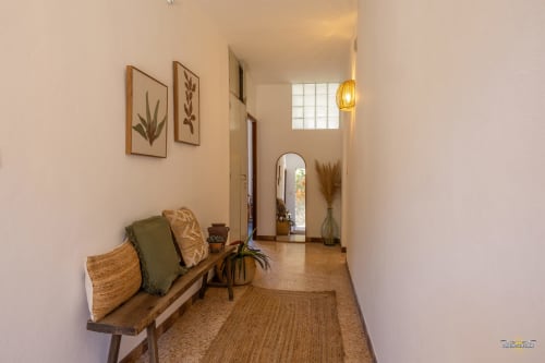 Couloir de villa moderne à Centuri avec banc en bois, œuvres botaniques, luminaires suspendus et vue mer