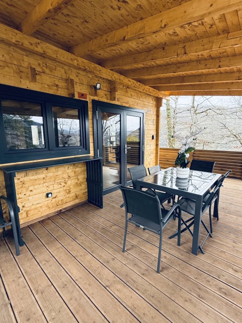 Terrasse couverte avec table à manger et chaises au Lodge l'ORCHIDÉE, Serrières-sur-Ain
