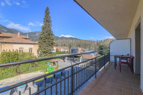 Spacious balcony terrace at Rural Montseny apartment in Gualba with mountain views, outdoor seating, and scenic landscape.