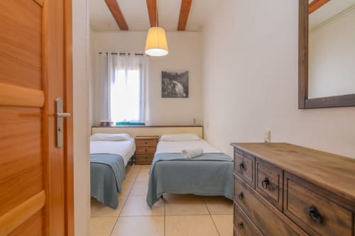 Twin beds in cottage bedroom at Rural Montseny, Gualba with wooden beams and rustic furnishings