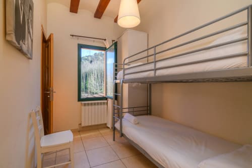 Bunk bed bedroom at Rural Montseny cottage in Gualba with mountain views through open window