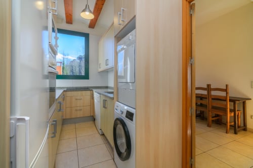 Modern kitchen and laundry area in Cal Metge cottage at Rural Montseny, Gualba with appliances and dining space