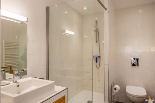 Salle de bain moderne avec douche ouverte, vasque et toilettes à la Villa CECILE à Centuri, Corse