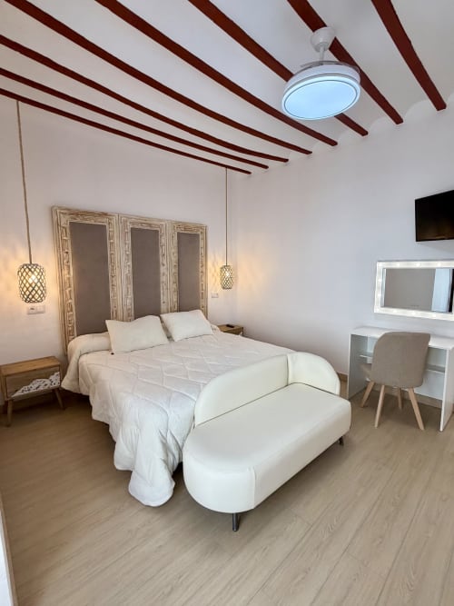 Modern bedroom at Complejo Turístico Retiro del Teatro in Almagro with queen bed, pendant lights, desk, and beam ceiling