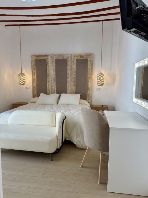 Modern bedroom at Complejo Turístico Retiro del Teatro with white bed, pendant lights, and decorative wooden panels in