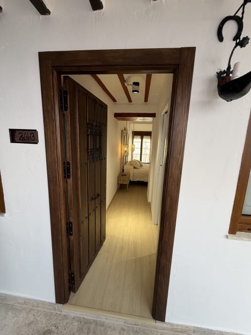 Hallway entrance to Room 203 at Complejo Turístico Retiro del Teatro, Almagro with wooden doors and beamed ceiling