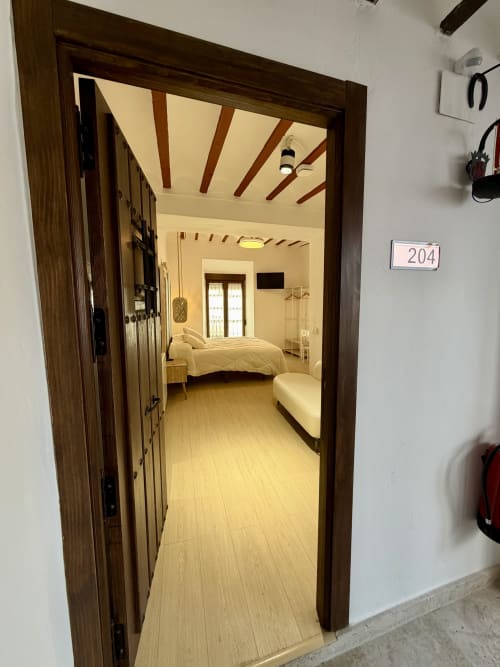 Room 204 at Retiro del Teatro, Almagro - bedroom with bed, wooden beams, and light flooring