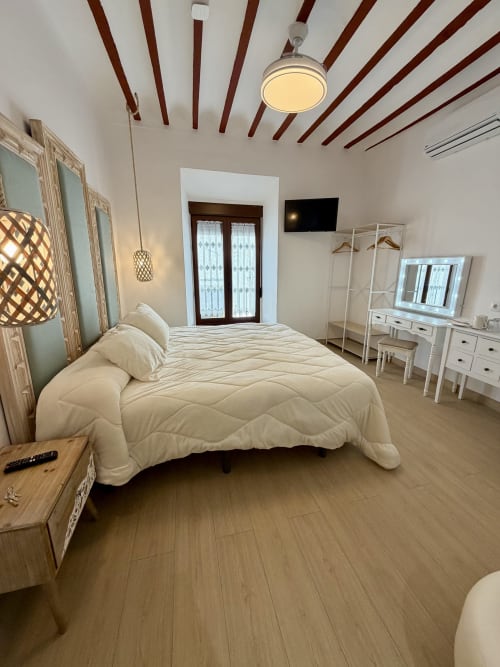 Modern bedroom at Complejo Turístico Retiro del Teatro in Almagro with queen bed, TV, and vanity desk