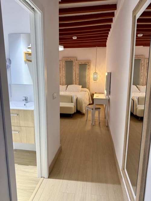Modern bedroom hallway at Complejo Turístico Retiro del Teatro with wooden flooring, mirrors, and bathroom entrance in