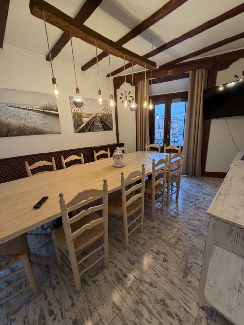 Comedor rústico con vigas de madera, iluminación colgante y vistas al campo en Complejo Turístico Retiro del Teatro, Almagro