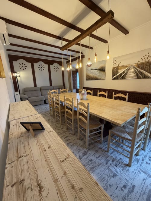 Amplio comedor y sala de estar en la cabaña Villa Corral de Comedias con vigas de madera, mesas rústicas y muebles modernos