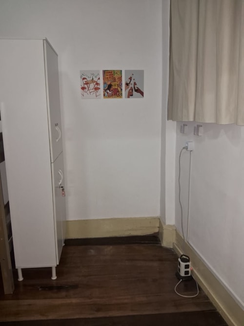Dormitório coletivo misto no Rio Vibes Hostel com armários brancos, piso de madeira e arte nas paredes no Rio de Janeiro