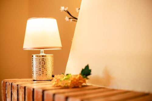 Golden lamp with white shade on wooden block at Finca Navalpino boutique hotel in Guadamur