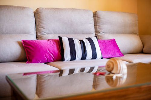 Cream sofa with pink and striped cushions at Finca Navalpino bed and breakfast in Guadamur, Spain