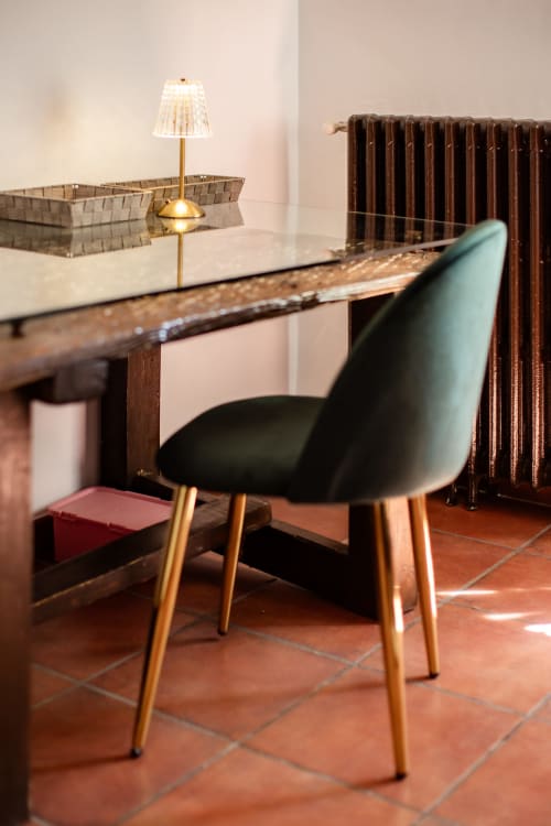 Modern workspace at Finca Navalpino with black chair, wooden desk, brass lamp, and radiator in Guadamur