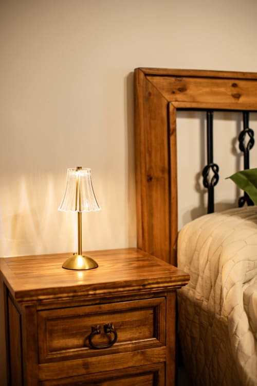 Mesilla de noche de madera con lámpara de latón en la habitación de Finca Navalpino, Guadamur