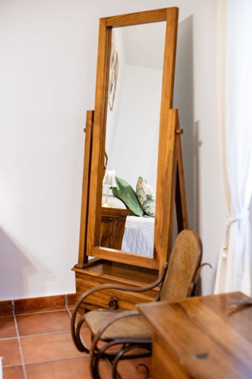Wooden standing mirror and chair in bedroom at Finca Navalpino, Guadamur
