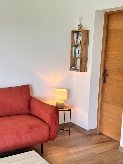 Salon moderne à In Casa Conciergerie, Figari avec fauteuil rouge, bibliothèque en bois et lampadaire jaune