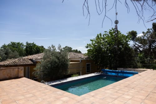 Swimming pool at Finca Navalpino B&B in Guadamur, Spain with terracotta terrace and rustic buildings