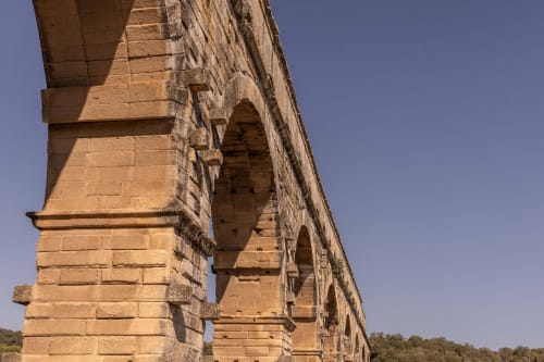 Ancient stone archway and pillars at Le Prieuré Notre-Dame historic property in Montfrin, France