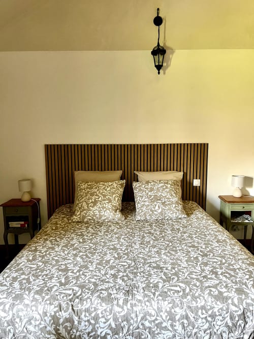 Chambre élégante au Manoir de Fornebello avec literie à motifs, tête de lit rayée et éclairage avec vue sur le jardin