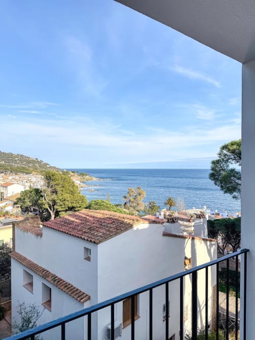 Mediterranean coastal view from Finques Garcia Enrich hotel in Palafrugell, Spain with whitewashed buildings and blue sea