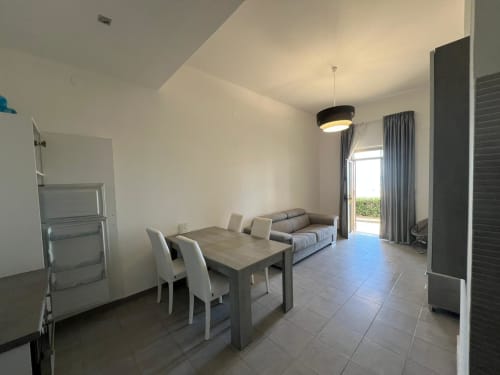 Zona living e sala da pranzo di moderno appartamento fronte mare a Marina di Strongoli con vista sul mare attraverso porte-finestre