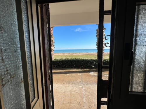 Porte aperte che incorniciano la vista sulla spiaggia dell'appartamento Il Mare Sotto Casa a Marina di Strongoli con mare, spiaggia sabbiosa e vegetazione